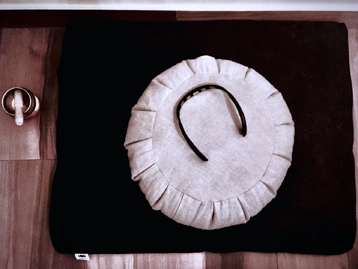 Zafu meditation cushion on a zabuton mat with the Muse 2 headband and a signing bell